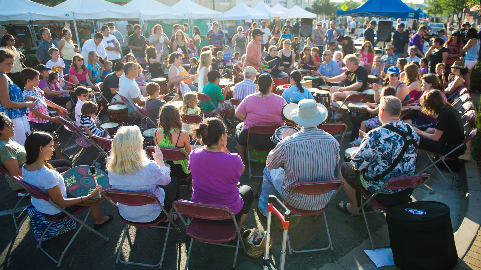 Chris Ramirez facilitating a drum circle at a farmers market